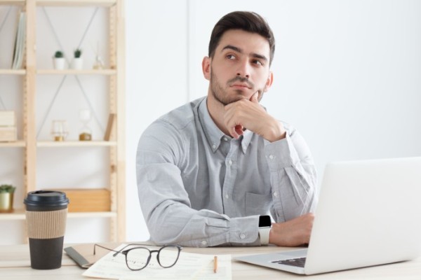 facet zastanawiający się przed laptopem